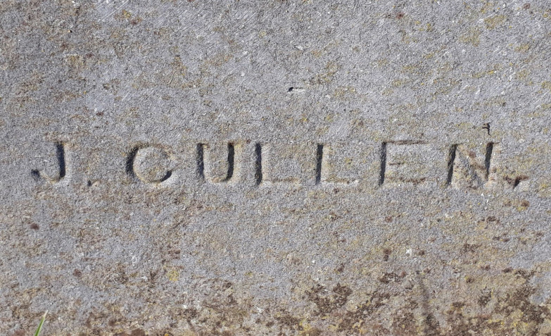 Image of a gravestone, carved with letters "J CULLEN"