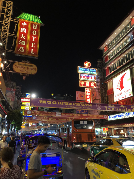 Yaowarat Road in Bangkok at night with bright street signs and busy streets.