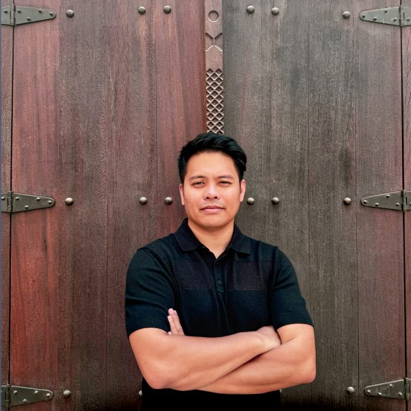 Portrait of Alfredo Marco Pradil of Hanken Design Co in front of wooden doors with metal details.