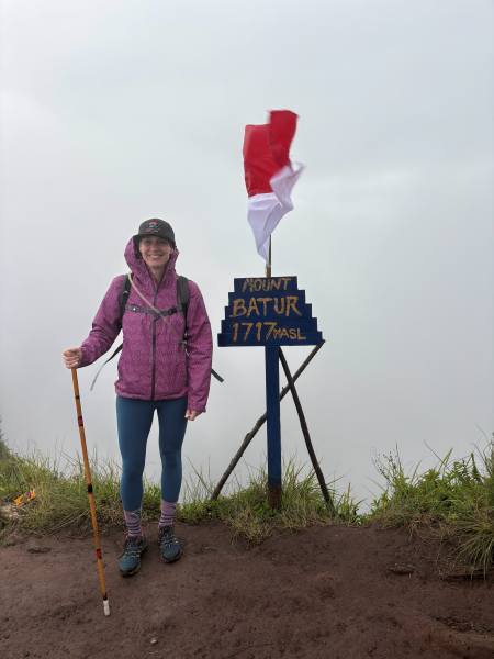 Kristin Ratzlaff at summit of Mount Batur in hiking gear. 