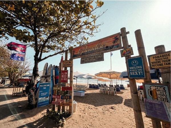A photograph of a variety of signs on the beach in Kuta.