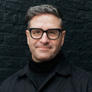 Portrait of Charles Nix wearing a black shirt in front of a black brick background cropped 16x9.