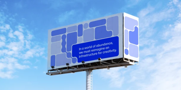 Billboard in front of a blue sky with light, airy clouds. Billboard features rounded box shapes and circles that fit together like smooth puzzle pieces. Text in white on blue background rounded rectangular-ish shape: "In a world of abundance, we must reimagine infrastructure for creativity.