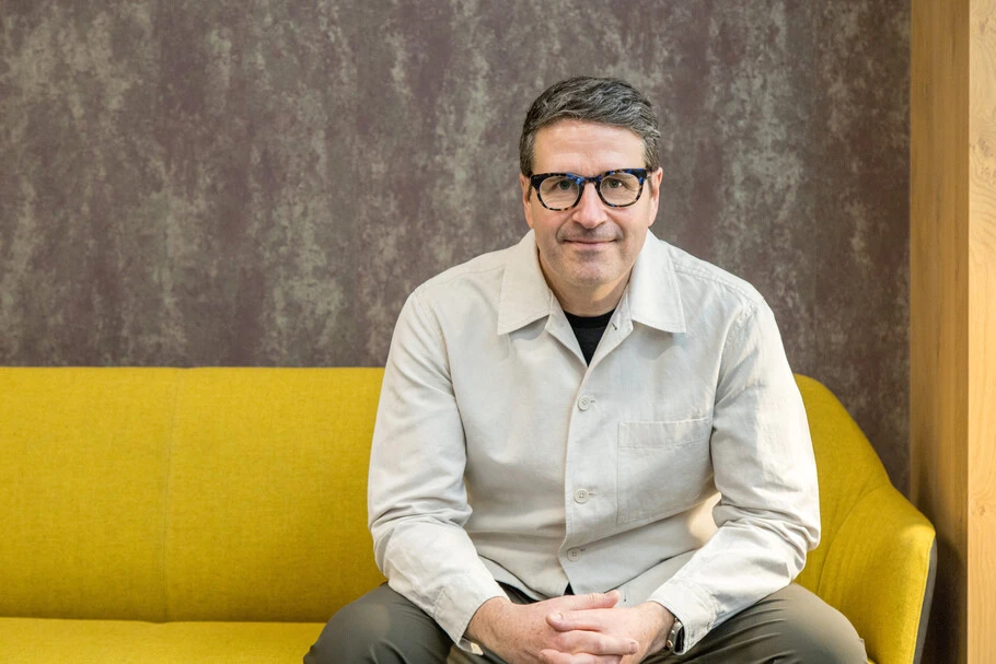 Charles Nix sitting for a portrait on a yellow couch.